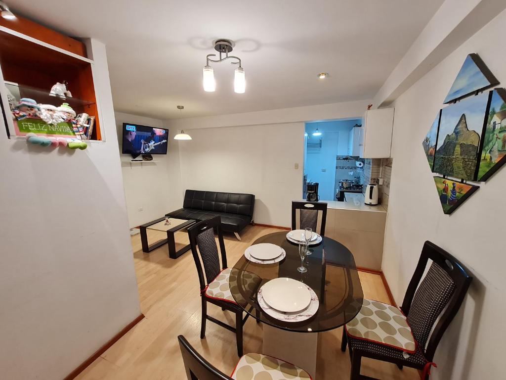 een eetkamer en woonkamer met een tafel en stoelen bij WASI in Cuzco