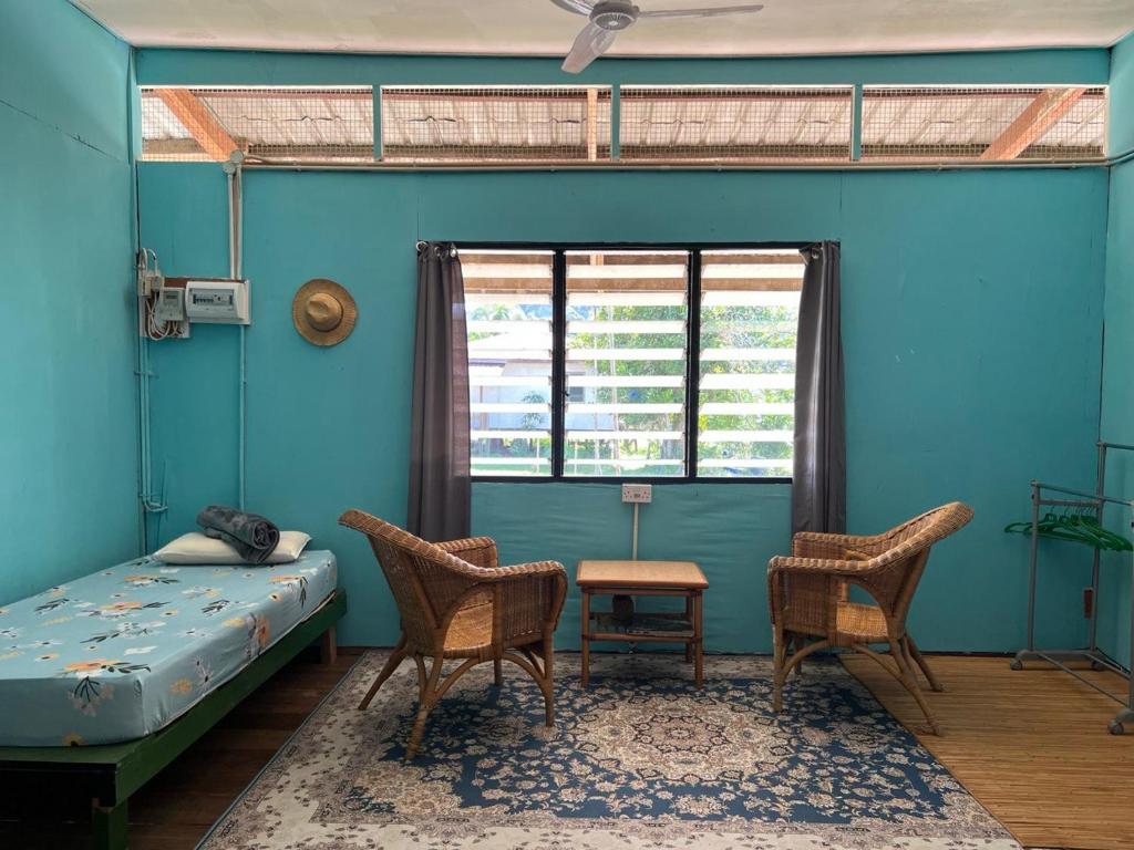 姆鲁Adventureswithst Homestay的客房设有床、两把椅子和窗户。