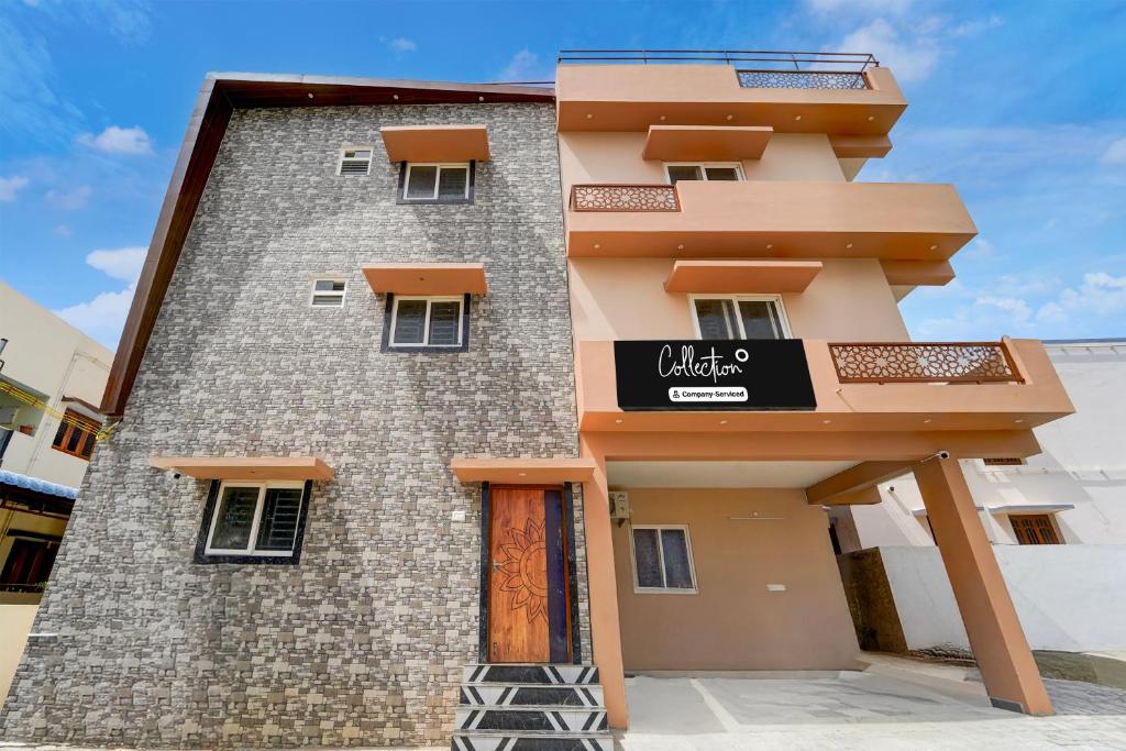 un edificio de ladrillo alto con un cartel. en Collection O MKU Madurai Formerly Mpl Elite, en Samayanallūr