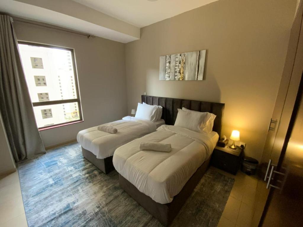 En eller flere senge i et værelse på Nuchi Jbr Hostel