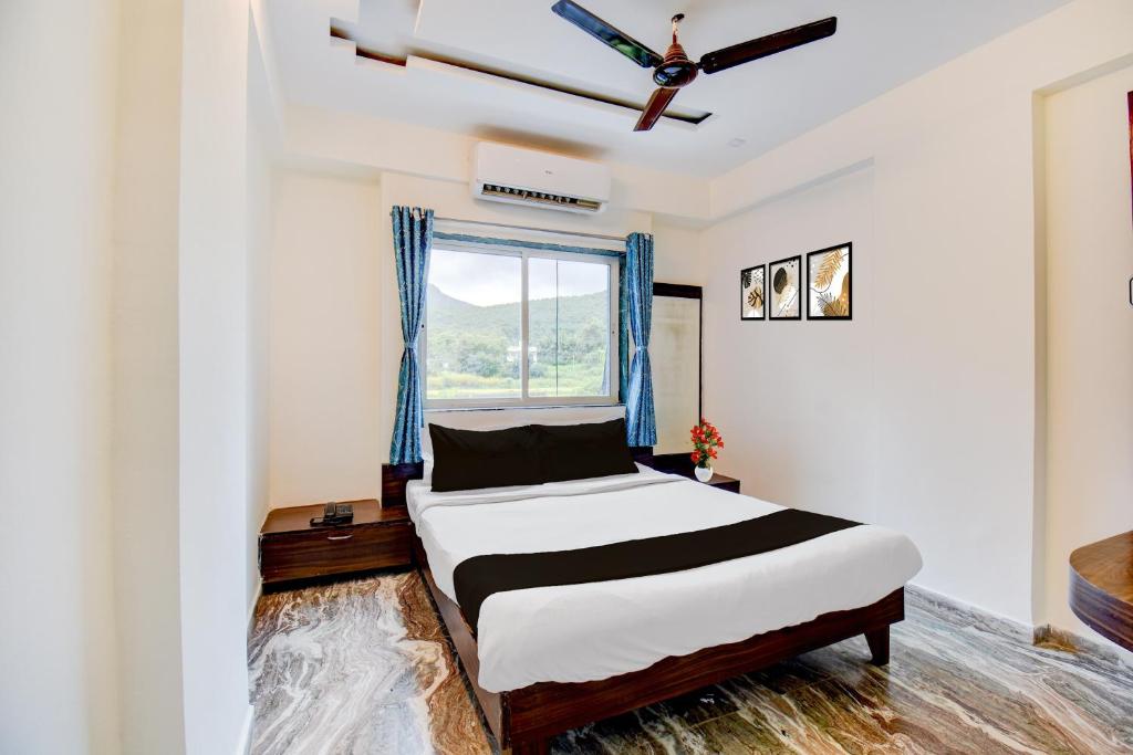 um quarto com uma cama e uma janela em Super Hotel O Khadakwasla Lakeview Formerly Gokul Lodge em Kharakvasla