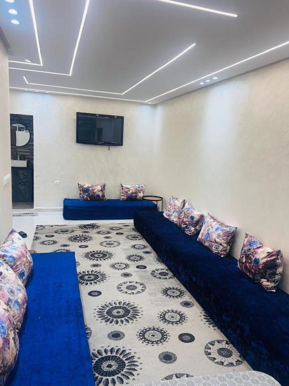 Una sala de estar con un sofá y un televisor de pantalla plana. en Appartement refait a neuf, en Bel Aroussi