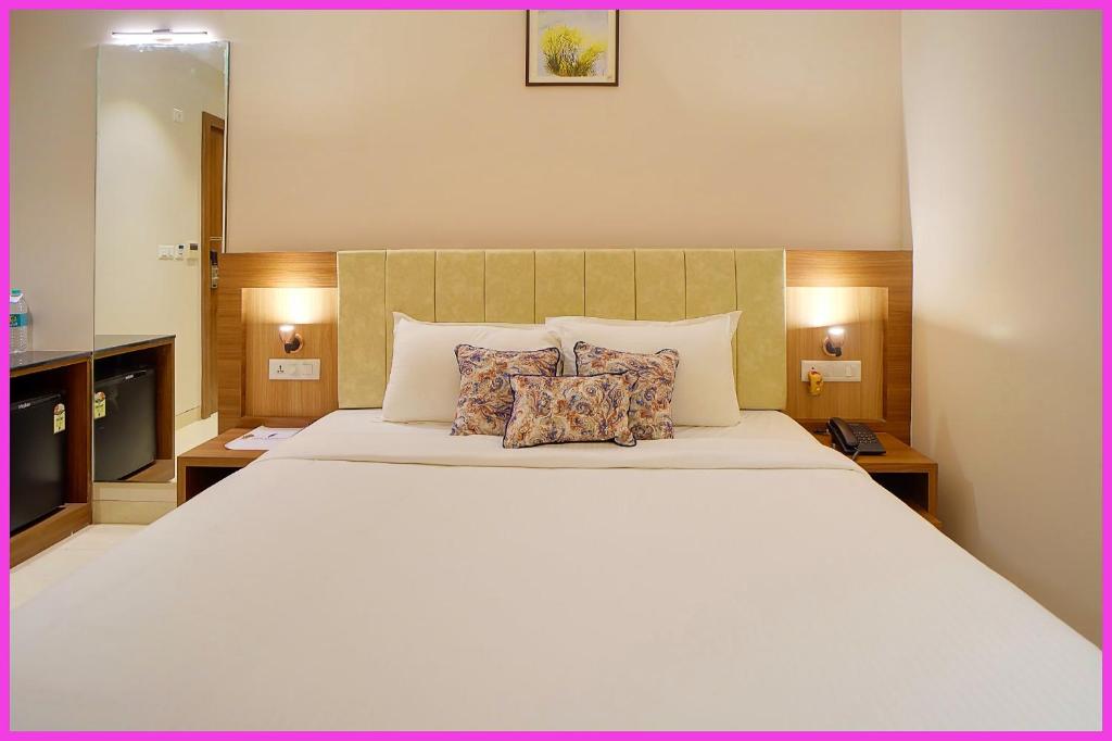 Un dormitorio con una gran cama blanca con dos almohadas. en New Marine Road BeachFront The Royal Bay Suite - Lift-Parking - Restaurant - Fully Air Conditioning Deluxe Rooms - A Best Luxuary Hotel, en Puri