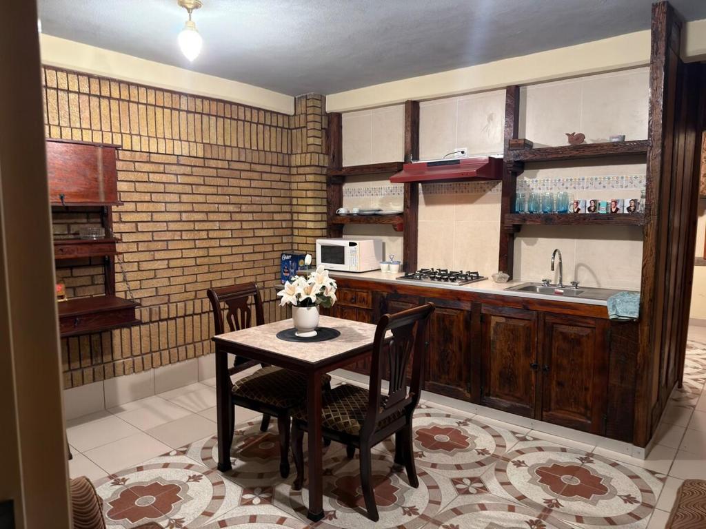 Departamento Nuevo Céntrico Las Marías 2 في سالتيلو: مطبخ مع طاولة وكراسي ومغسلة