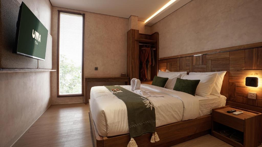 a bedroom with a large bed and a window at Uma Tilu By Seken Living in Yogyakarta