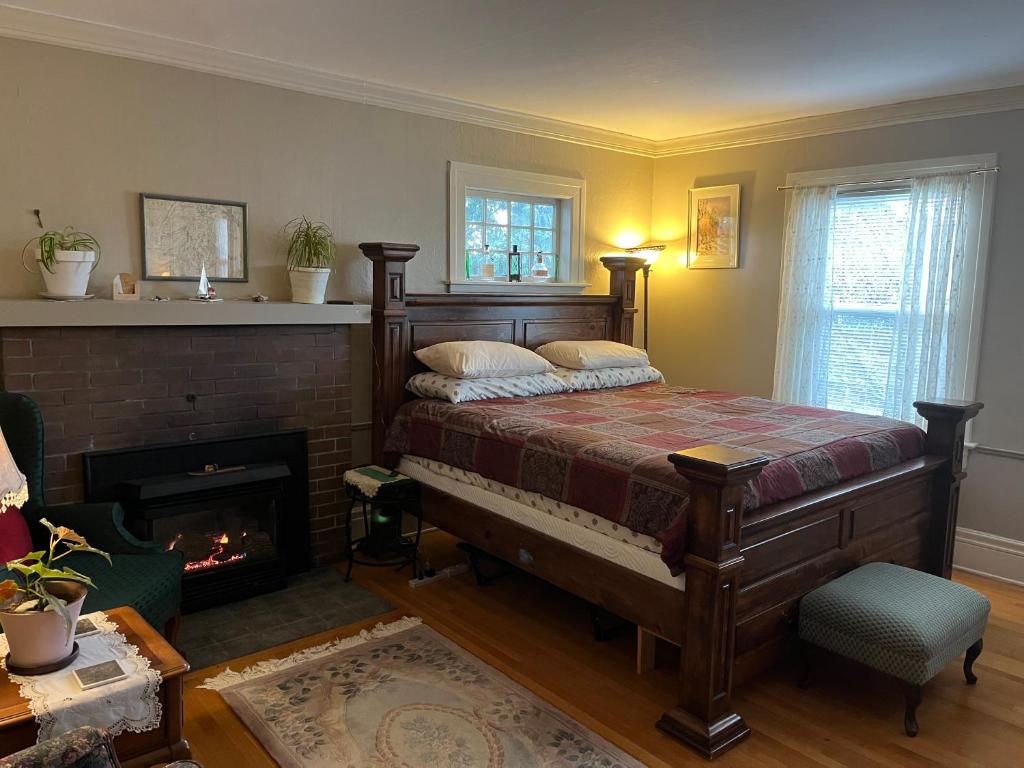 a bedroom with a bed and a fireplace at Plum Duff House in Tacoma