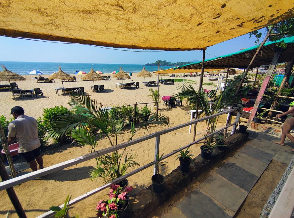 a beach with chairs and umbrellas and the ocean at Mountain Palm patnem beach in Patnem