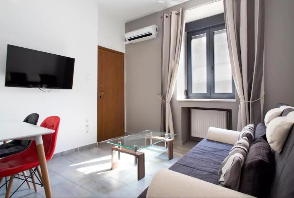 sala de estar con sofá, mesa y TV en Gazi Boutique Apartment 2 en Atenas