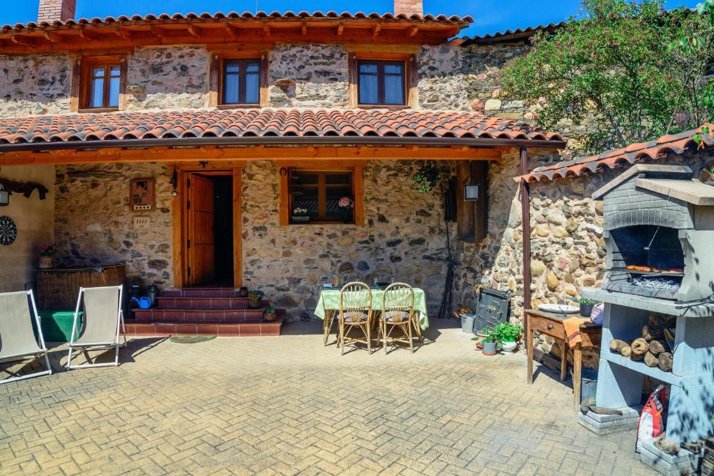 Casa de piedra con patio y chimenea en Casa Rural Entre Valles, en Benllera