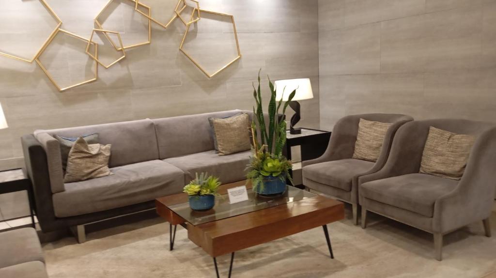 ein Wohnzimmer mit zwei Sofas und einem Couchtisch in der Unterkunft Sea Residences Moa Staycation- EVEREST in Sampong