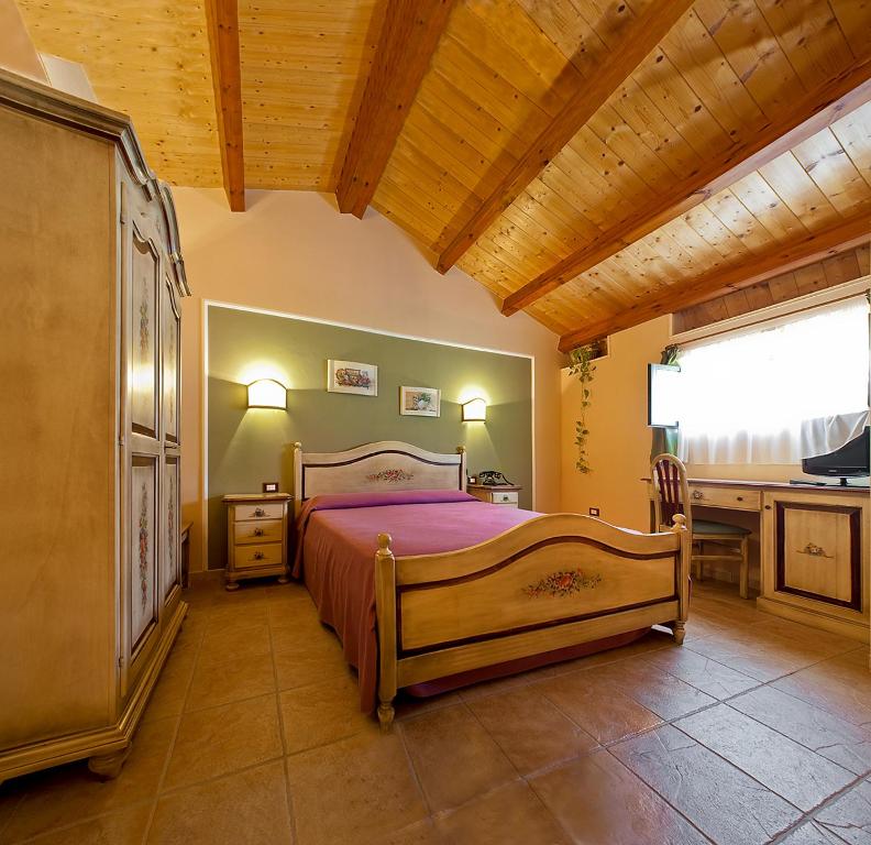 um quarto com uma cama, uma secretária e uma janela em B&B Liu' Palazzo Ducale em Lesina