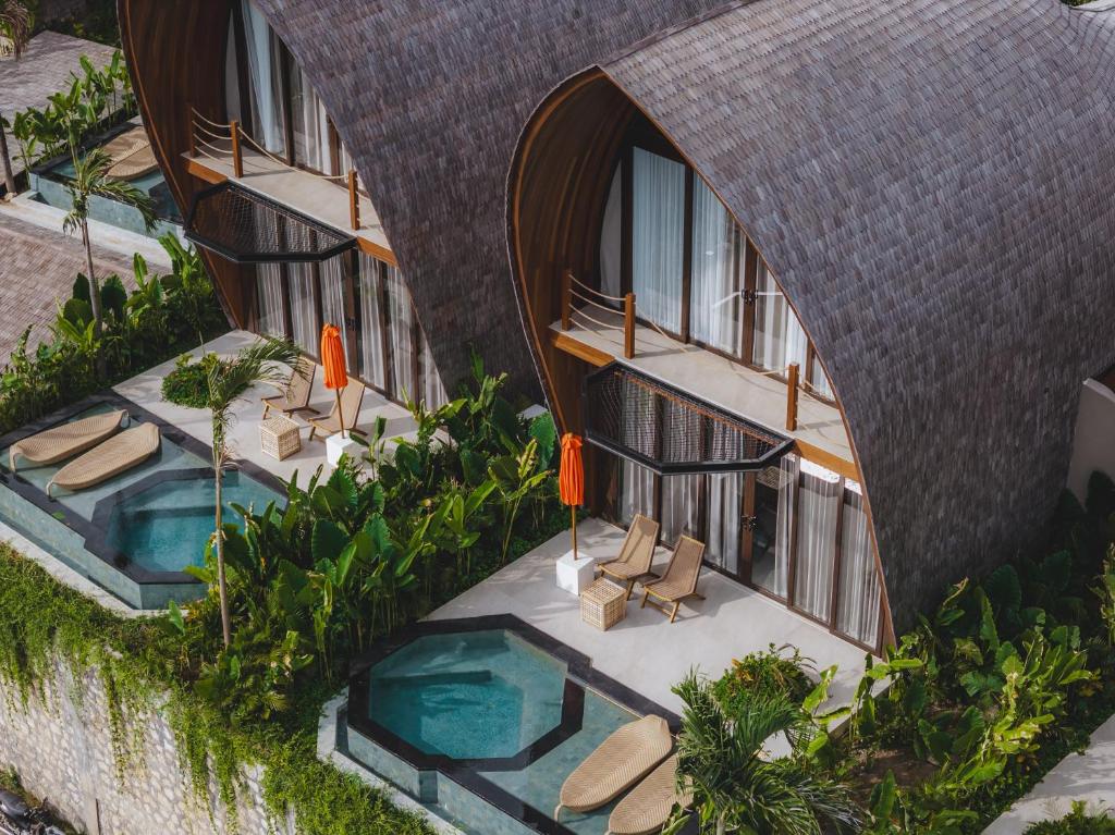 einen Luftblick auf ein Gebäude mit Pool und Stühlen in der Unterkunft Cactus Village Penida in Nusa Penida