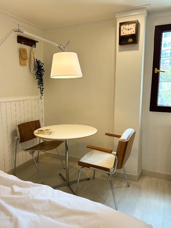 mesa y sillas en una habitación con cama en 포켓서울 문래점, en Seúl
