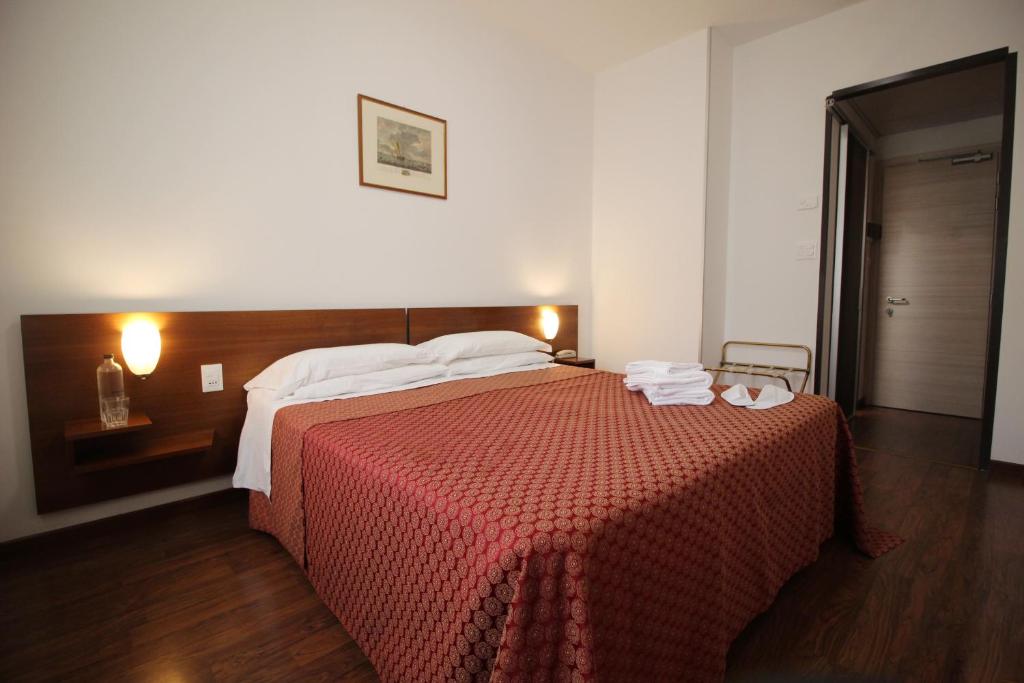 Un dormitorio con una cama grande con una manta roja. en Hotel Salieri, en Legnago