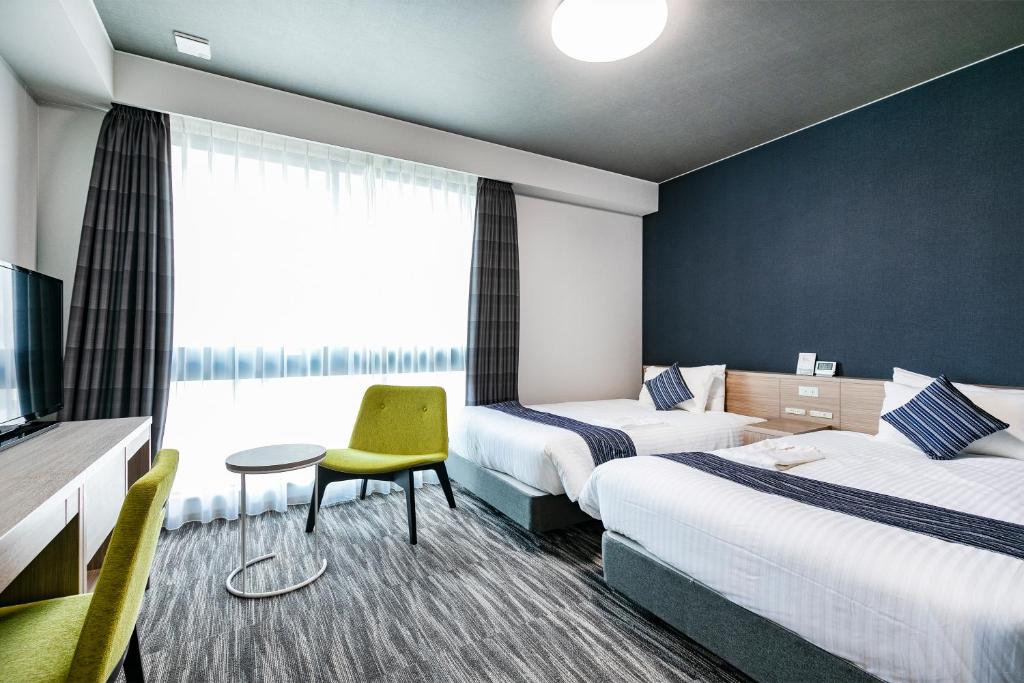 福岡市にある静鉄ホテルプレジオ博多駅前のベッド2台とテレビがあるホテルの部屋