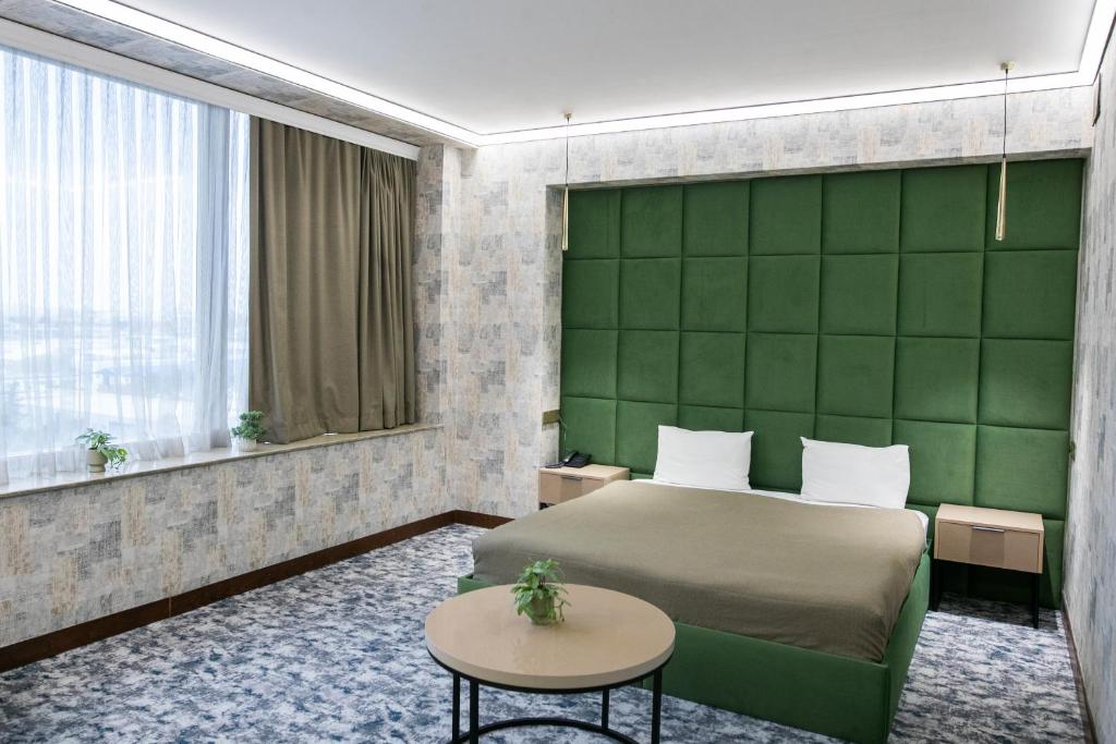 a bedroom with a bed and a green wall at Innab Inn Hotel in Baku