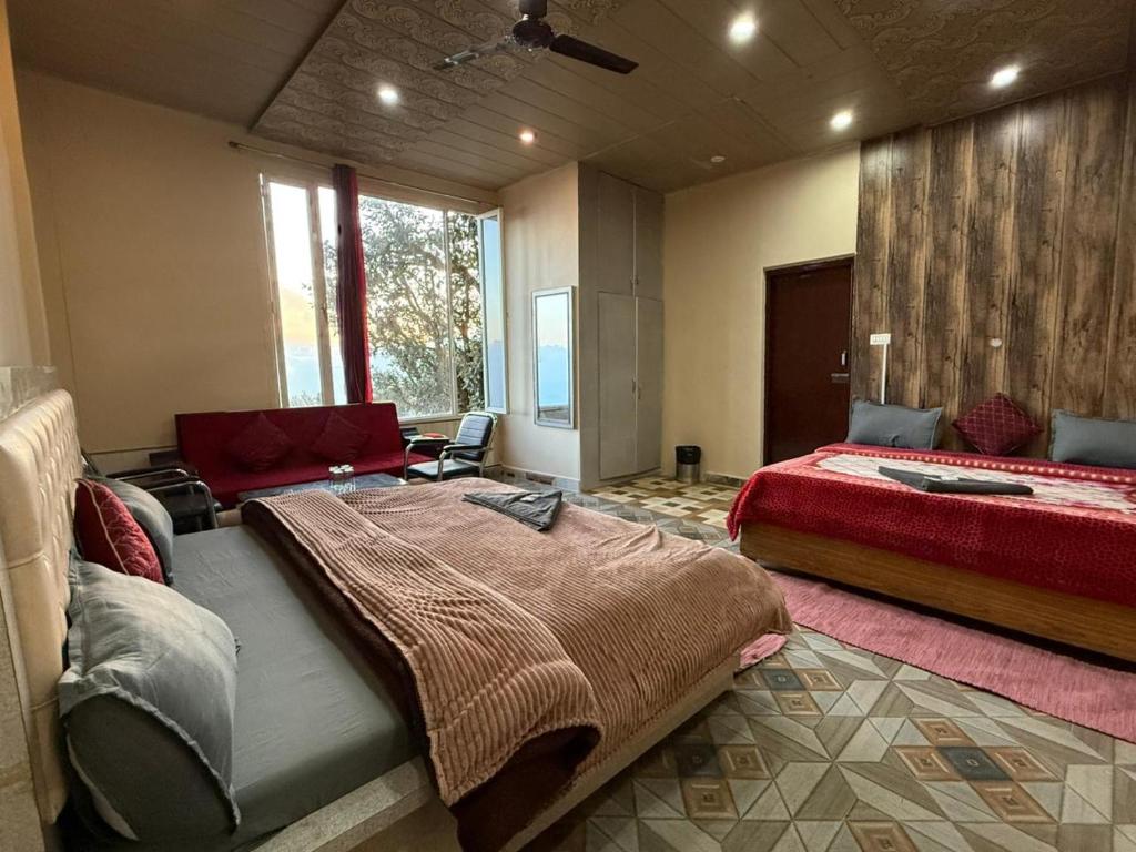 a large bedroom with two beds and a couch at Hotel Sunrise Inn & Restaurant, Kanatal in Chamba