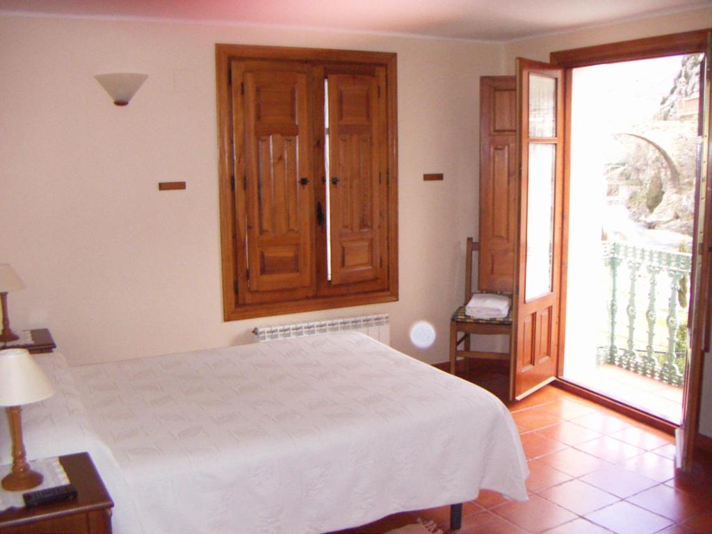 a bedroom with a white bed and a large window at Casa Rural Peñalba in Arnedillo
