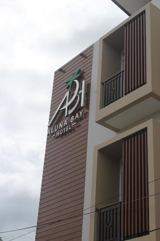 een bord aan de zijkant van een gebouw bij Aluna Bay Hotel in Balige