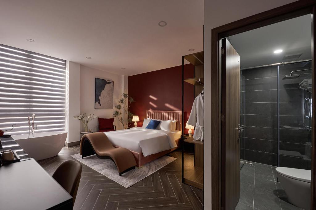 um quarto de hotel com uma cama e um banheiro em Lovera Hotel Airport em Cidade de Ho Chi Minh