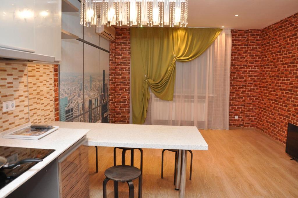 a kitchen with a table and two stools at ART Hostel in Almaty