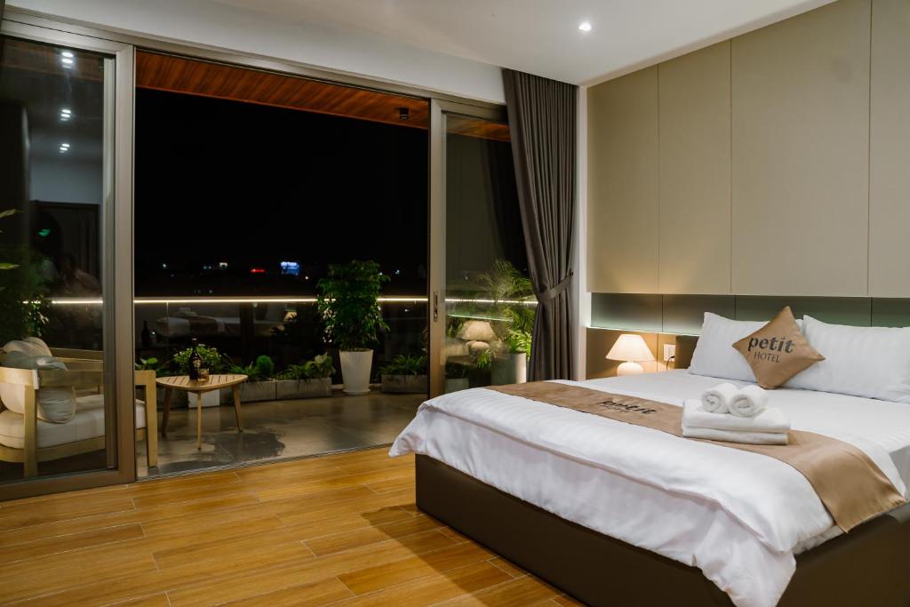 um quarto com uma cama grande e uma janela grande em Petit Hotel em Thu Dau Mot