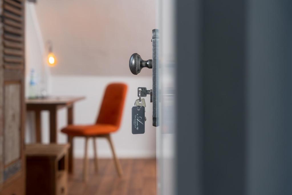 een deur met een sleutel in een kamer met een stoel bij ARTHOTEL Herrsching in Herrsching am Ammersee