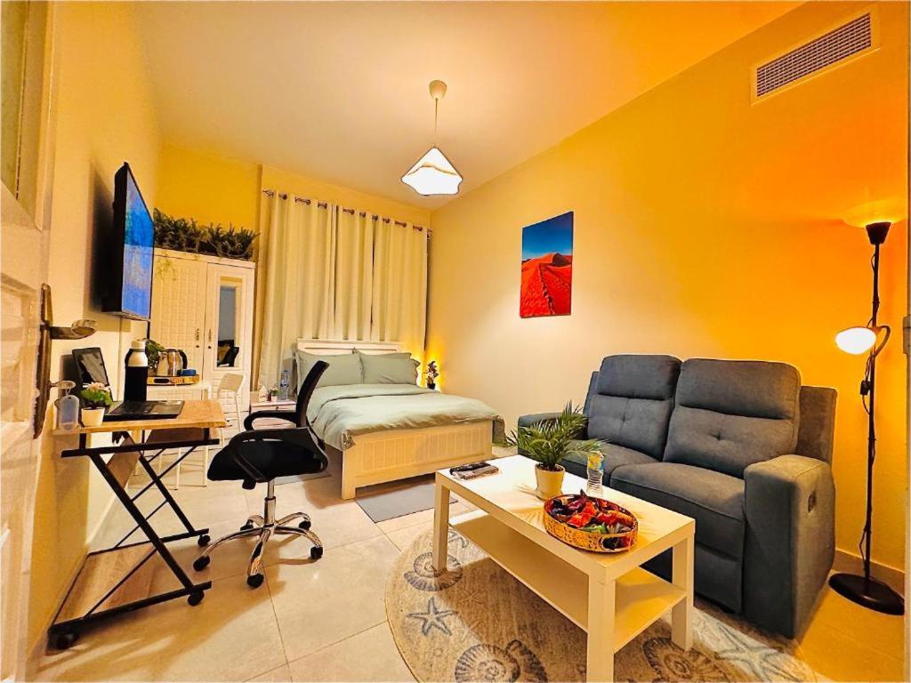 una sala de estar con un sofá y una cama en DSV Property, en Abu Dabi