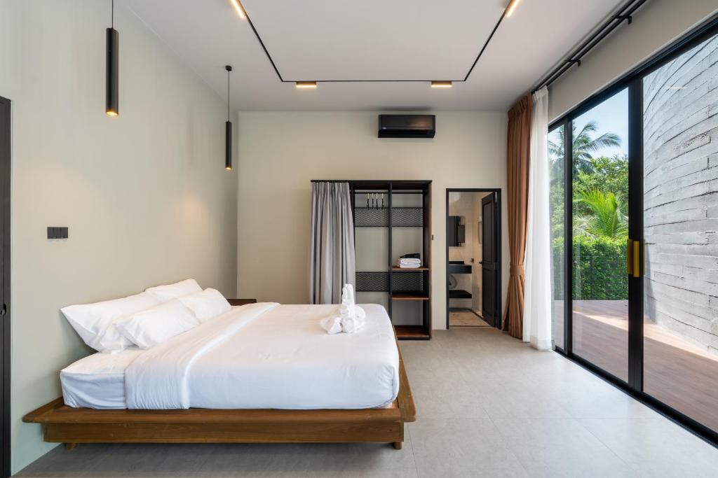 een slaapkamer met een wit bed en een groot raam bij Balance Village in Ko Phangan