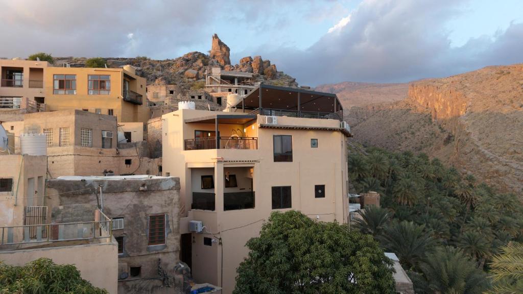 a group of buildings with a mountain in the background at Bait Falaj Al Misfah Hospitality in Misfāh