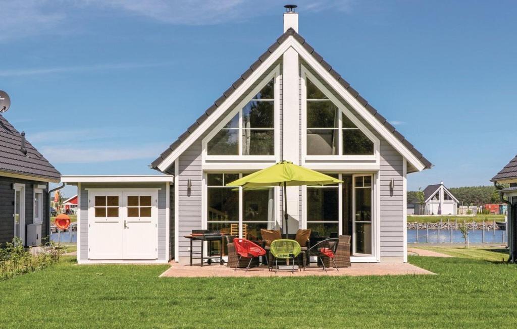 een huis met een gele paraplu en een tafel en stoelen bij Haus Hafenblick in Wandlitz