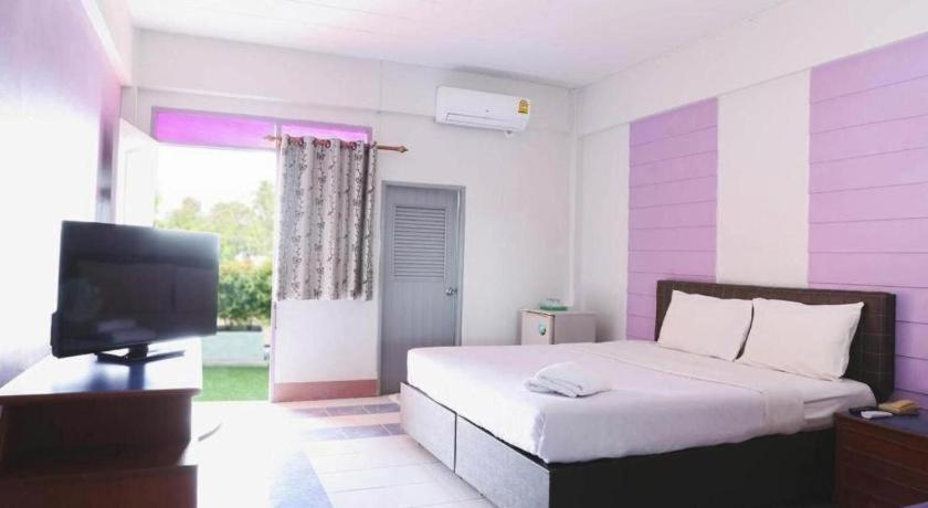 Un dormitorio con una cama y un televisor de pantalla plana. en Kumkaew Udon, en Udon Thani