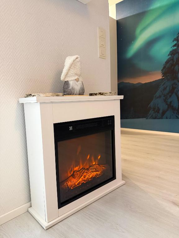 a fireplace in a living room with a fire at Aurora Home Rovaniemi in Rovaniemi