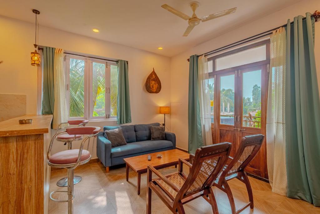 a living room with a couch and a table at Palmera Home Stay in Siolim
