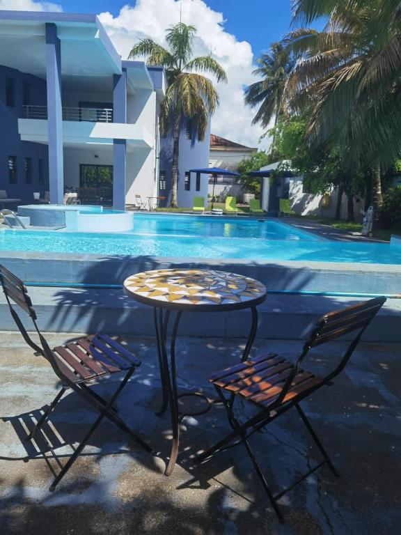 a table and two chairs next to a pool at "FLORIDA" - Guest-house Tamatave in Toamasina