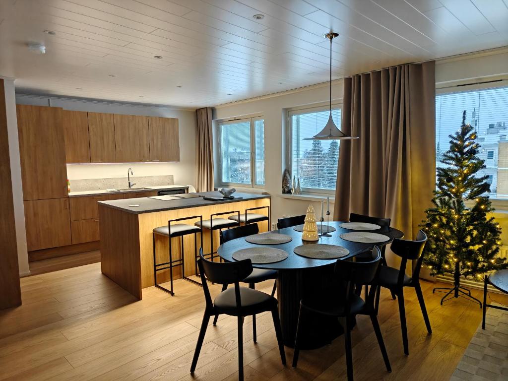 Penthouse Kemi في كيمي: مطبخ مع طاولة مع كراسي وشجرة عيد الميلاد