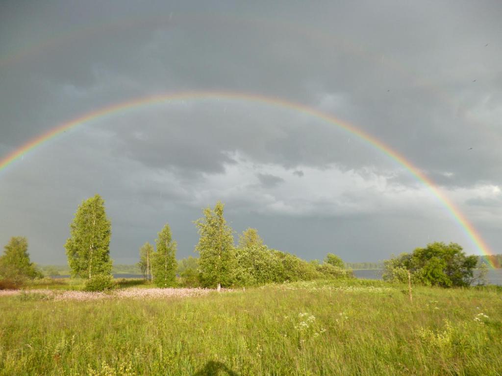 un arco iris en el cielo sobre un campo en International Camp club Bereg Best Beach Stylish Coastline Ukleyno Lake National Park Valdai, en Maloye Ukleyno