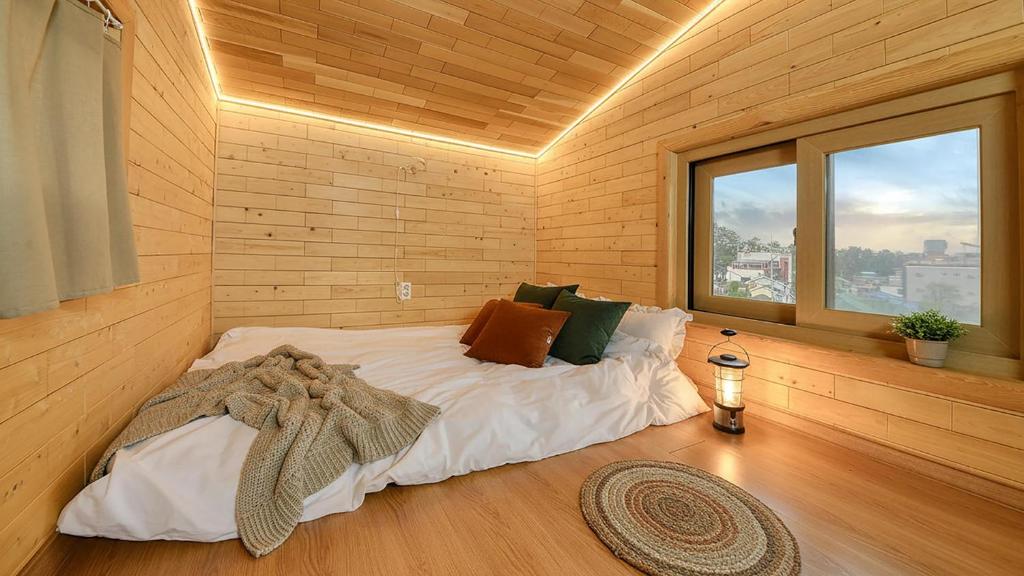 a bedroom with a bed in a room with a window at Samcheok View of Sea Pension in Samcheok