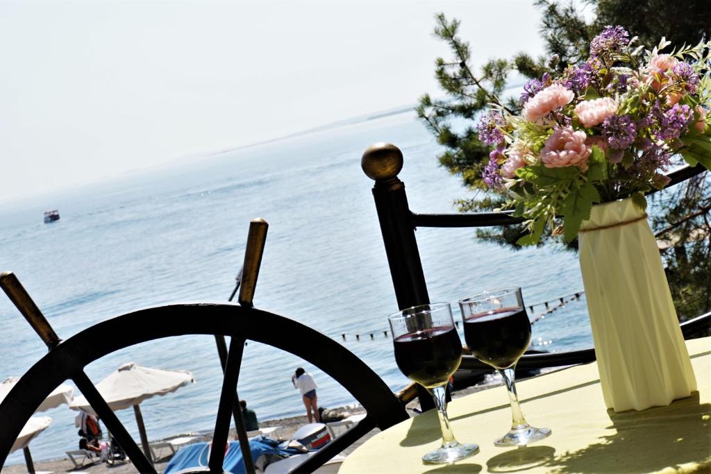 una mesa con dos copas de vino y un jarrón de flores en Чичхани Chichxani Kambuz, en Aghk'ilisa