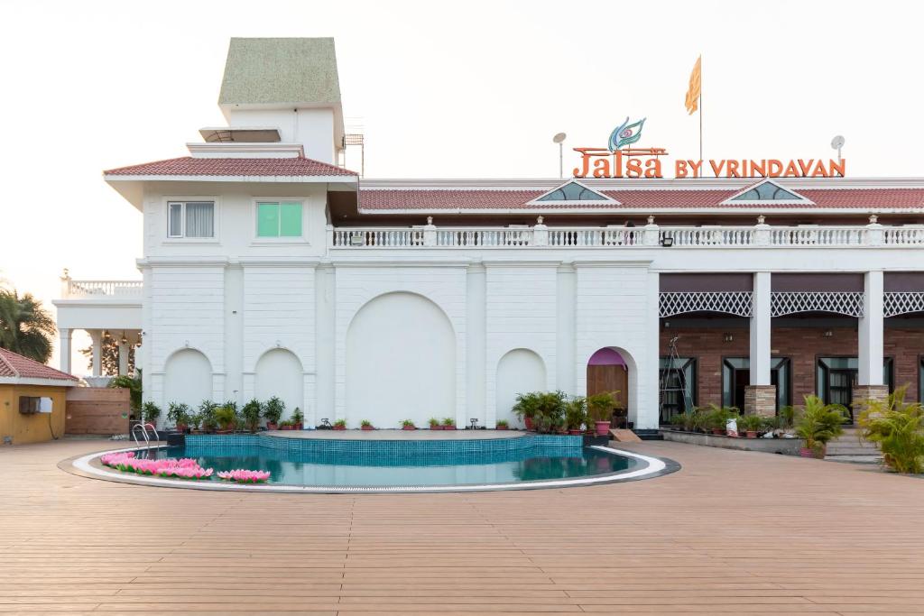 a white building with a fountain in front of it at JALSA HOTEL & BANQUETS,Indore in Indore
