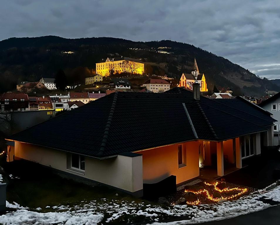 Ein Haus mit Dach, im Hintergrund eine Stadt in der Unterkunft Dreamliner Bungalow Murau in Murau