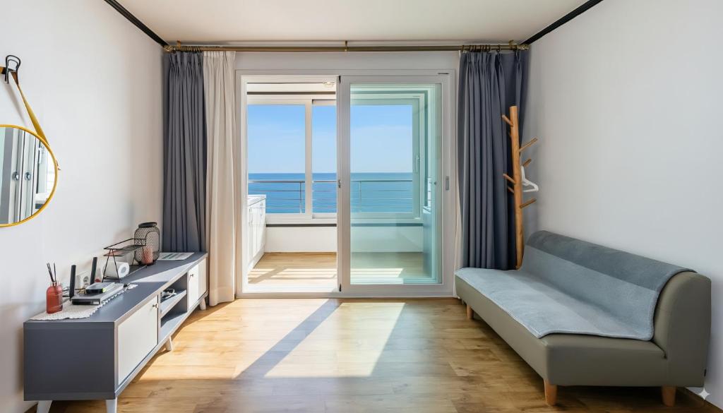 ヤンヤンにあるYangyang Verit Pensionのソファがあり海が見えるリビングルーム