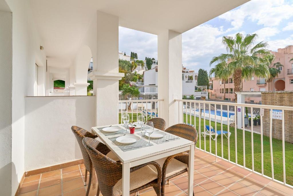 een eetkamer met een tafel en stoelen op een balkon bij Apto 3 Almoraide Suites in Nerja