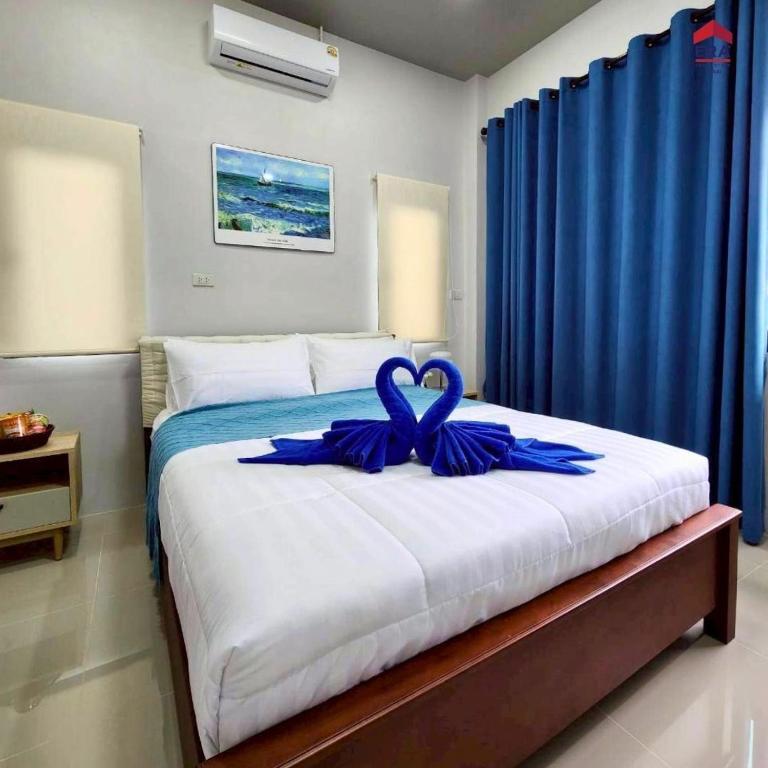 a bedroom with a bed with a blue ribbon on it at Aqua pool villa in Ban Nong Thale