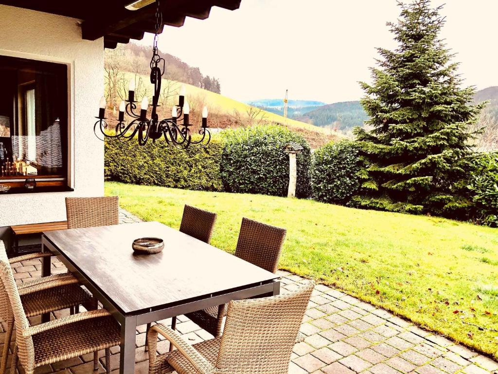 a dining table and chairs on a patio at Ferienhaus Rothaarblick in Schmallenberg