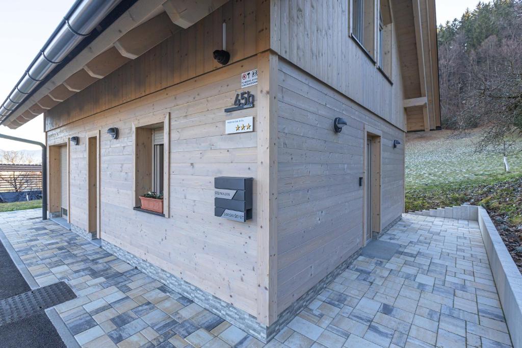 布莱德Počitniška hiša Gorski Šepet Bled的一座木结构建筑,其侧面有标志