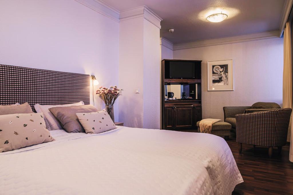 Hotel Seurahuone في كوكولا: غرفة نوم بها سرير أبيض كبير مع تلفزيون