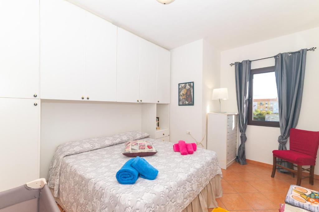 um quarto com uma cama e uma cadeira vermelha em Pupureddu con Terrazza ad Olbia em Olbia