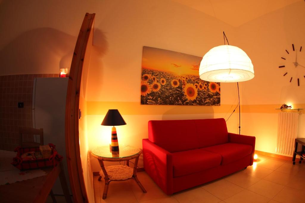 マテーラにあるLa Casetta del Vicinatoのリビングルーム(赤い椅子、時計付)