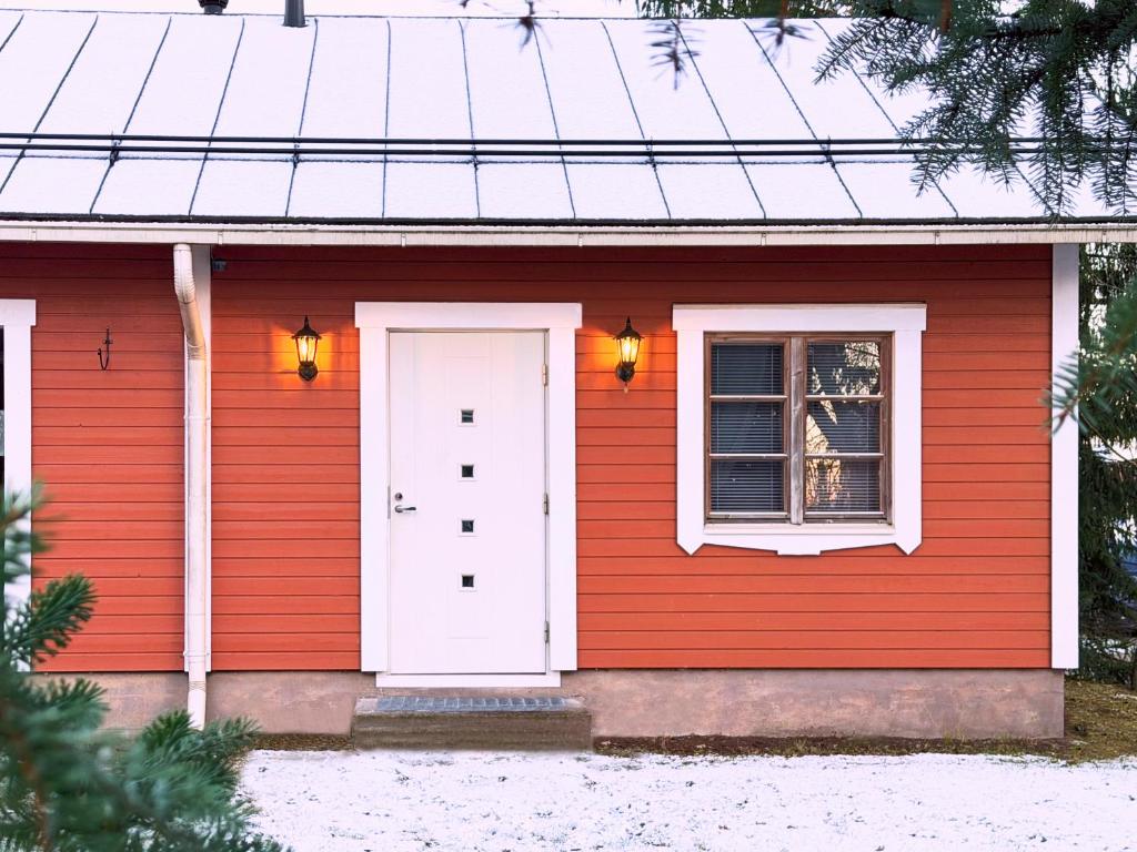 ein rotes Haus mit einer weißen Tür und einem Fenster in der Unterkunft Guest House Salo-City in Salo